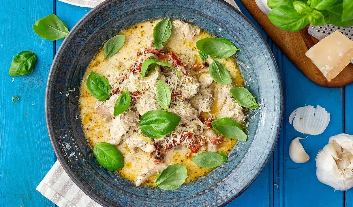 Krämig kyckling med soltorkade tomater, toppad med färsk basilika och parmesan. En härlig rätt som doftar Italien.