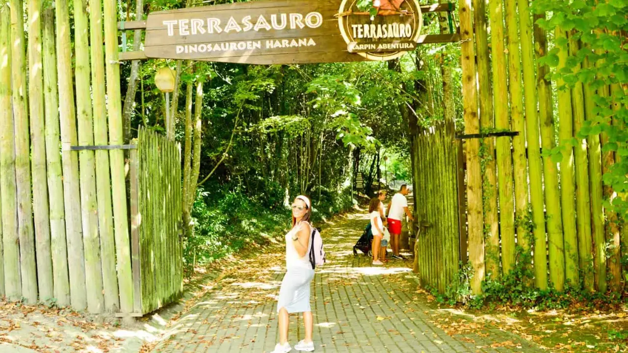 Una familia disfruta de un día en el **País Vasco con niños** en un parque temático de dinosaurios.