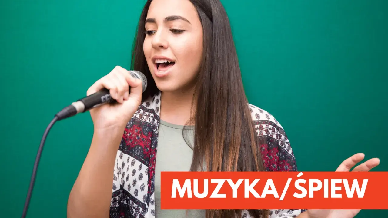 Młoda kobieta z mikrofonem w dłoni, wpatrzona w dal, z otwartymi ustami, jakby wykonywała śpiew operowy.