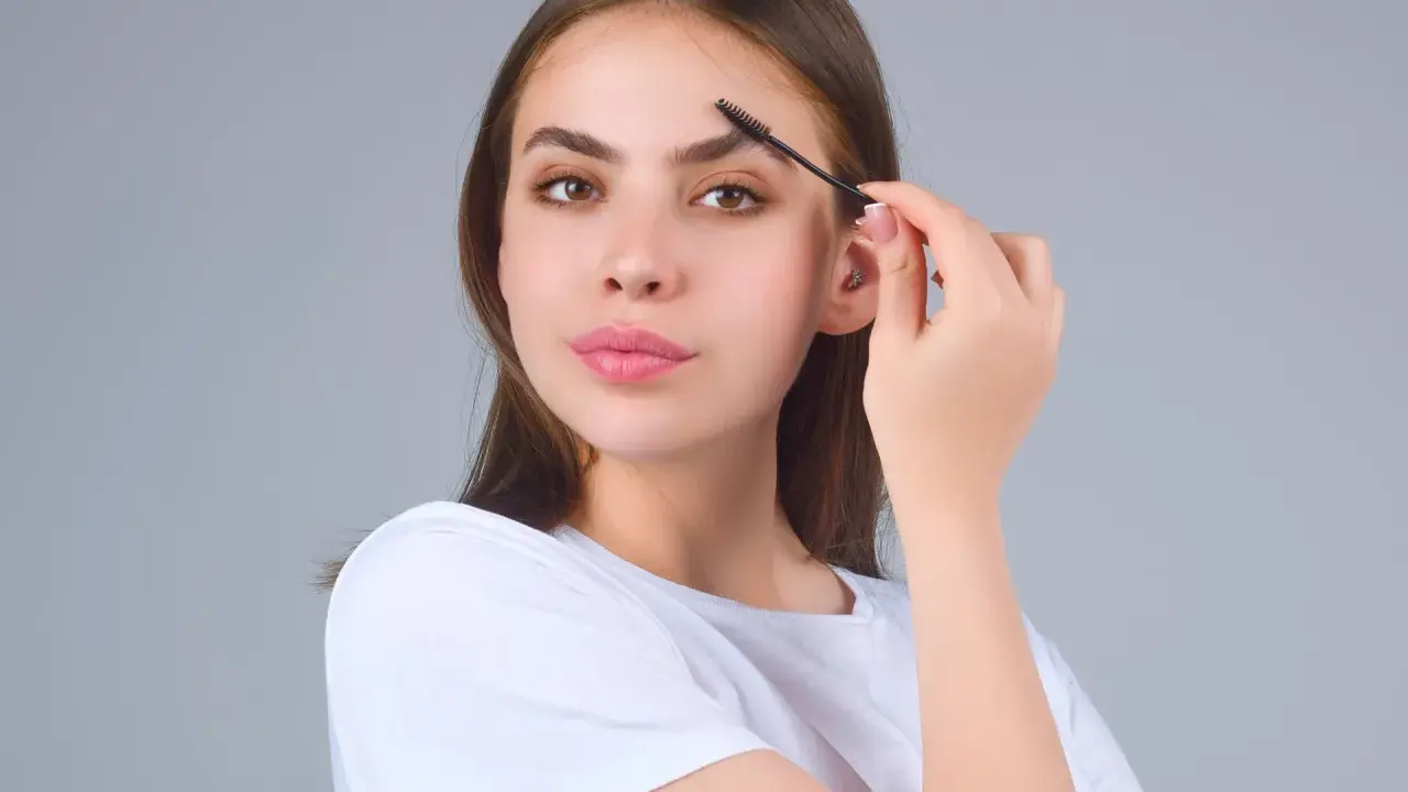 Jeune femme se brossant les sourcils. Une préoccupation pour la perte de sourcils avec l'âge, mais ici, ils sont parfaits.