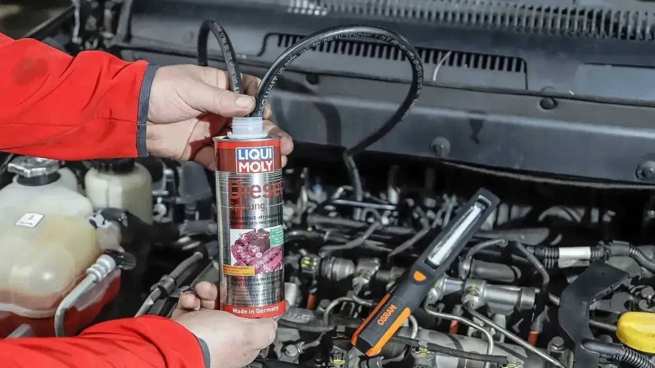Mechanik używa preparatu do czyszczenia wtryskiwaczy w silniku diesla.