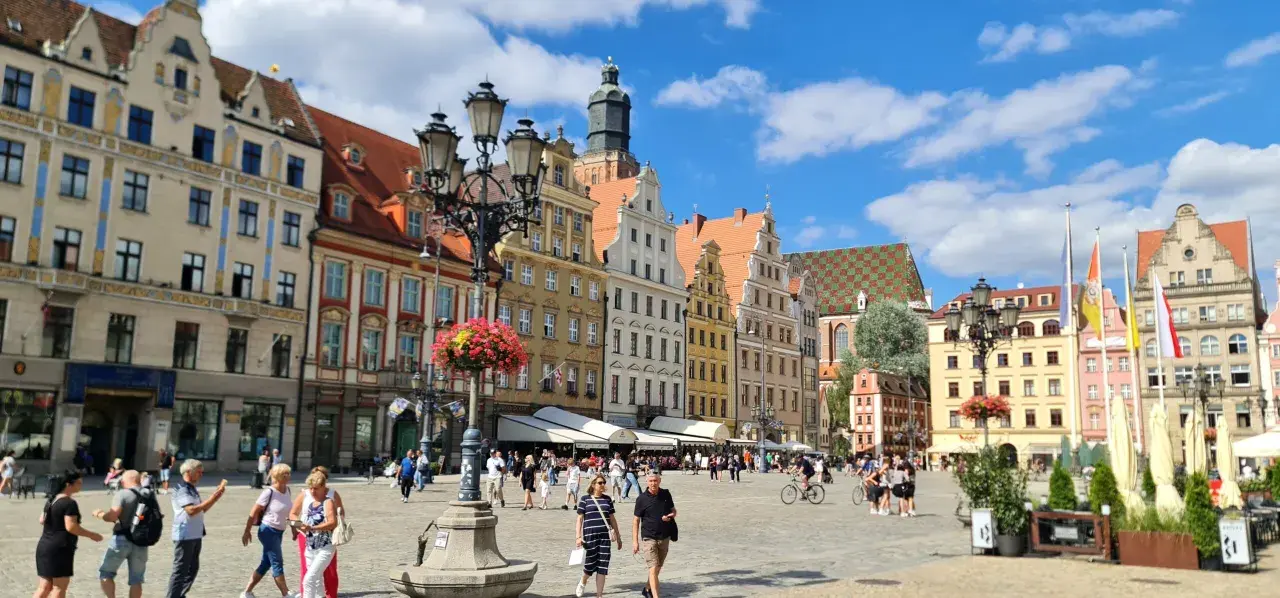Tętniący życiem Rynek we Wrocławiu, kolorowe kamienice i ludzie spacerujący po placu. To wspaniałe wrocławskie atrakcje!
