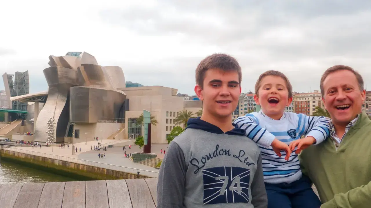 Familia disfrutando de un día en Bilbao con niños, con el icónico Museo Guggenheim de fondo.