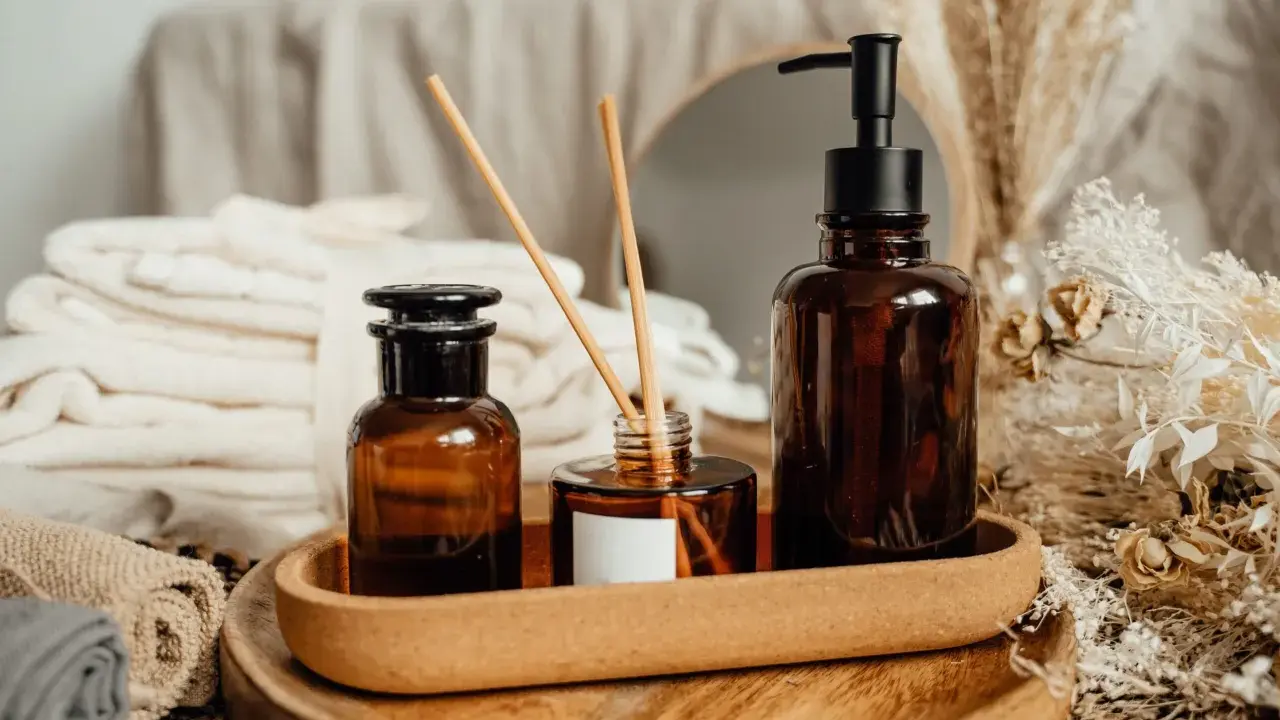 Ambiance zen avec diffuseur et flacons ambrés. Découvrez comment parfumer sa maison pour longtemps avec ces essentiels.
