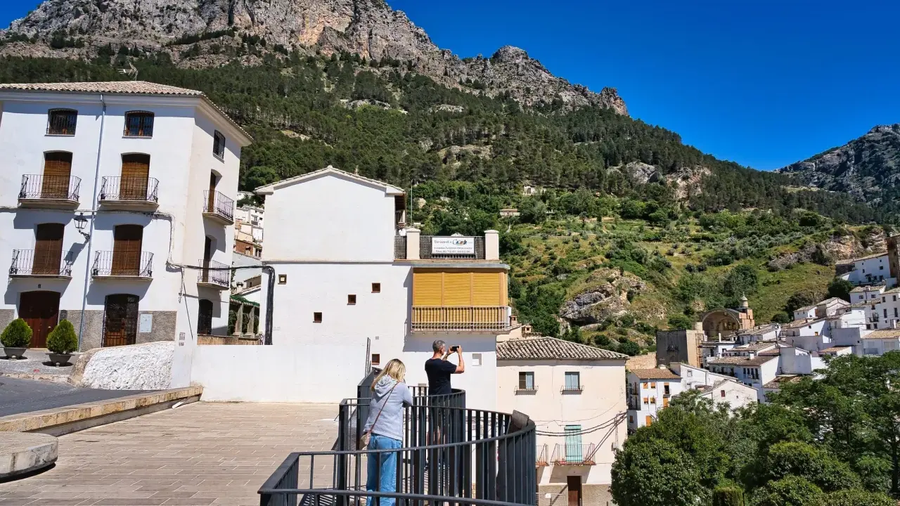 Pareja admira la vista de pueblos bonitos de Jaén, con casas blancas y montañas verdes.