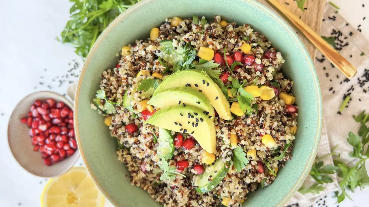 Bunter Quinoa Salat mit Avocado, Granatapfelkernen, Mais und frischer Petersilie. Ein gesundes und leckeres Gericht.
