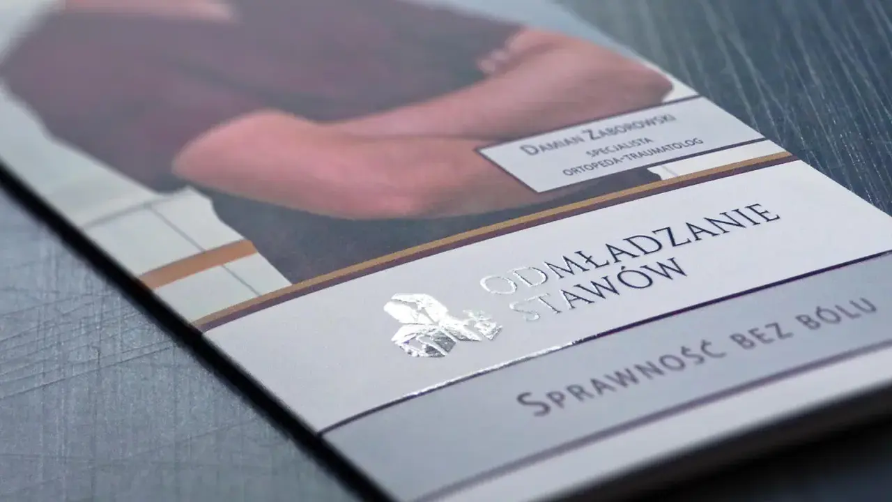 Ulotka z Damiana Zaborowskim, specjalistą ortopedii, reklamuje "Odmładzanie Stawów". Folia soft skin nadaje jej elegancki wygląd.