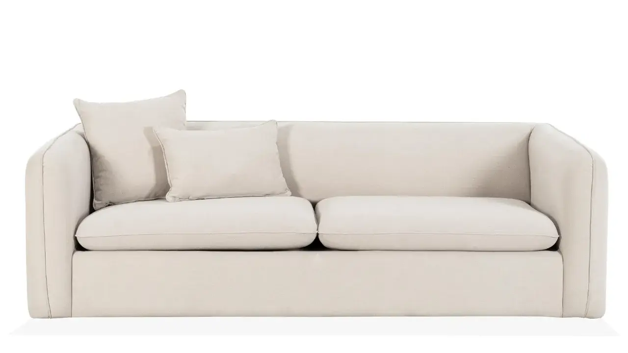 En ljusbeige bäddsoffa med två kuddar. Perfekt för gäster eller en mysig kväll.