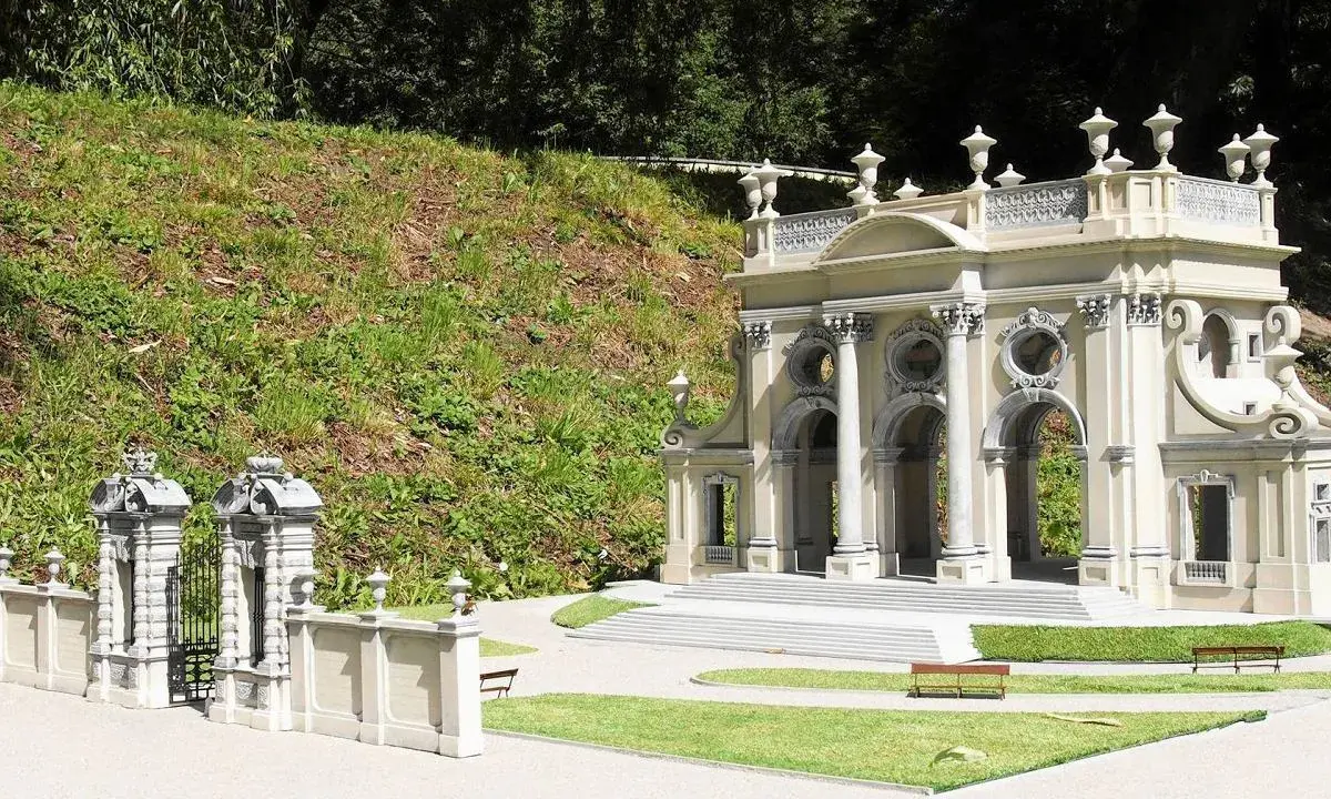 Miniaturowa budowla z kolumnami i bramą, jak w parku miniatur województwa mazowieckiego.