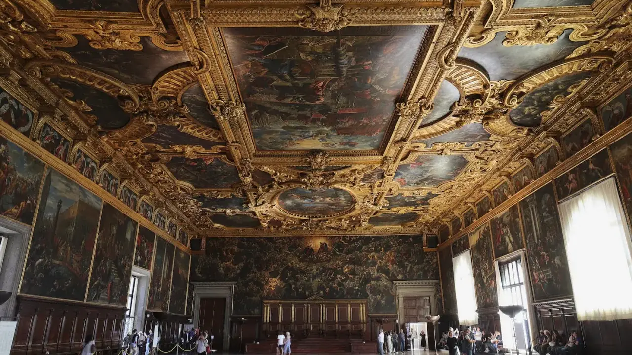 La salle du grand conseil du palais des doges, un chef-d'œuvre orné de peintures et de dorures, accueille des visiteurs émerveillés.