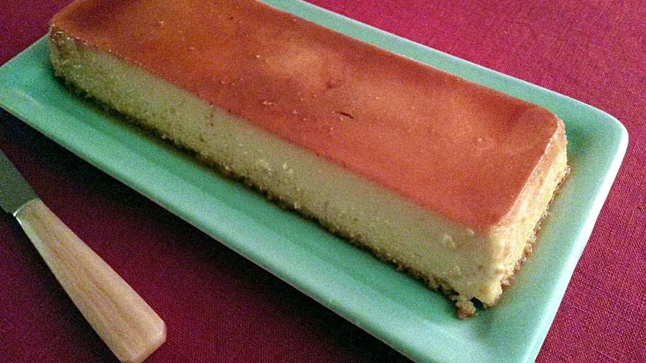 Un délicieux flan antillais, doré et onctueux, prêt à être dégusté sur une assiette verte.