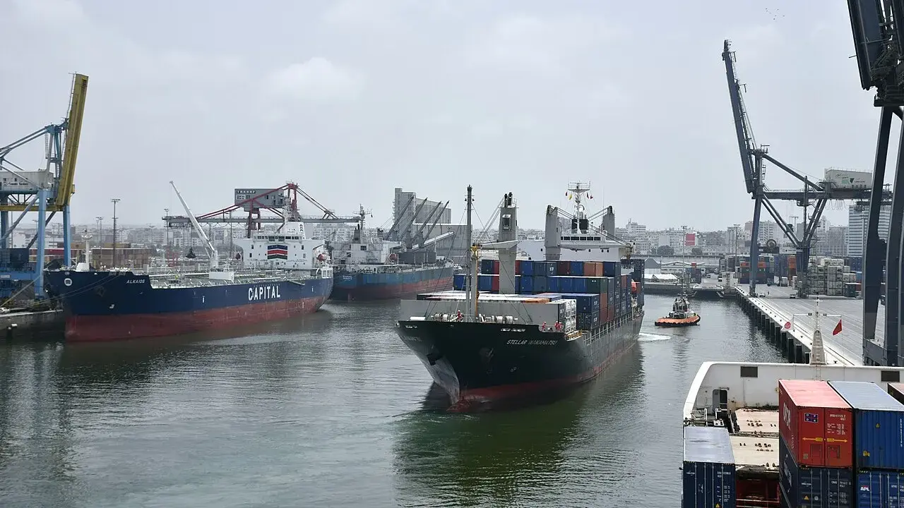 Navi da carico e gru nel porto di Casablanca. Un rimorchiatore assiste una nave portacontainer.