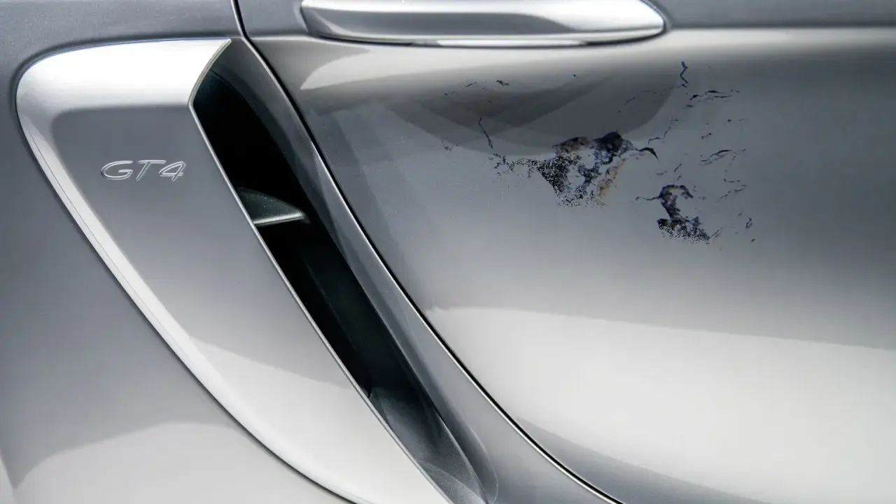 Na srebrnym lakierze Porsche GT4 schodzi lakier bezbarwny, tworząc nieestetyczne plamy. Jak naprawić ten problem?
