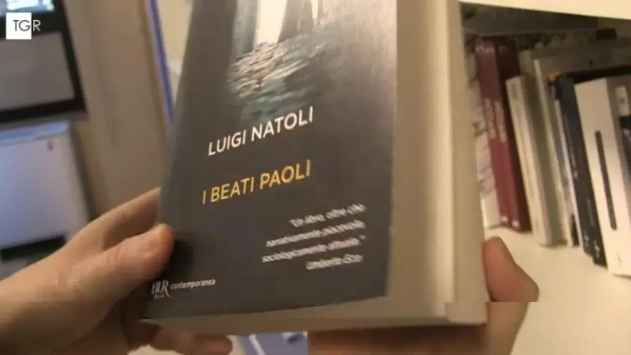Mani che sfogliano "I Beati Paoli" di Luigi Natoli, un libro che promette narrazione avvincente e analisi sociologica.