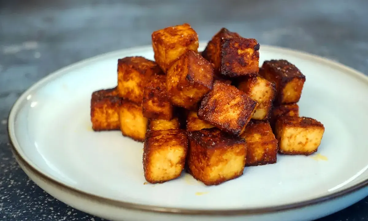 Goldbraun gebratene Tofuwürfel auf einem Teller, perfekt zum tofu zubereiten.