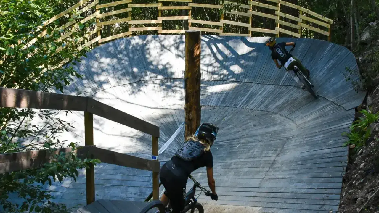 Två cyklister på en träbana i skogen, en spännande mtb-upplevelse nära Stockholm.
