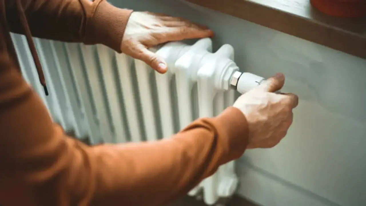 Manas ajustando el termostato para limpiar radiadores y optimizar la calefacción.