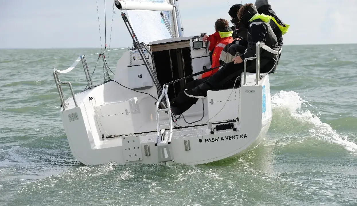 Équipage sur un voilier polonais transportable naviguant sur une mer agitée.