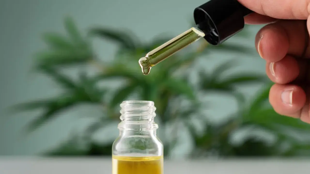 Une goutte d'huile essentielle tombe d'un compte-gouttes dans un flacon. Un remède naturel pour la toux grasse.