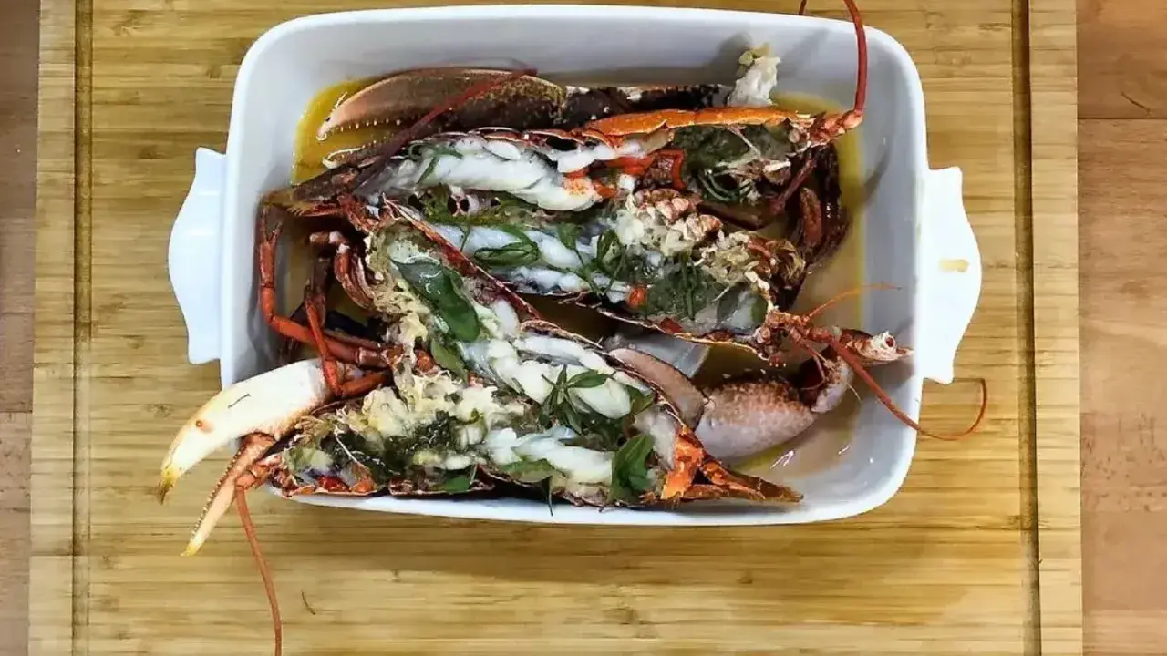 Homards bleus préparés dans un plat blanc, prêts pour une recette savoureuse.