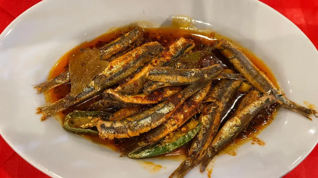 Piatto di alici marinate, un classico dei piatti tipici calabresi pesce, condite con olio, peperoncino e aromi.