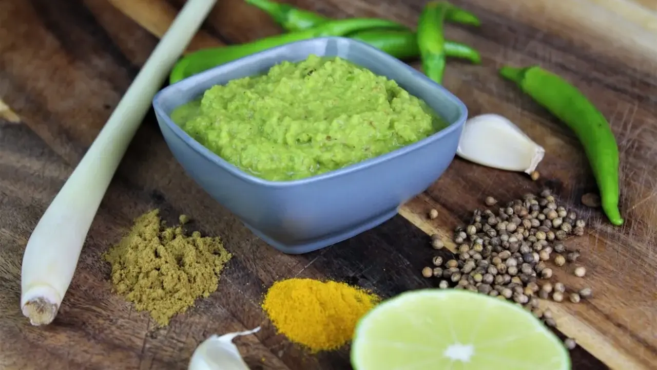 Frische Zutaten für **Currypaste selber machen**: grüne Chilis, Zitronengras, Knoblauch, Koriandersamen, Kurkuma, Kreuzkümmel und Limette.