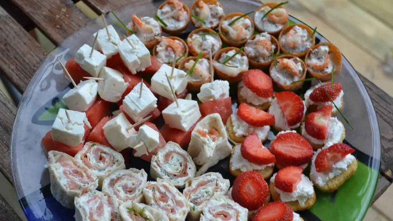 Enkla snittar till många: laxrullar, fetaost med vattenmelon, jordgubbar med grädde och räknyheter. Perfekt för festen!