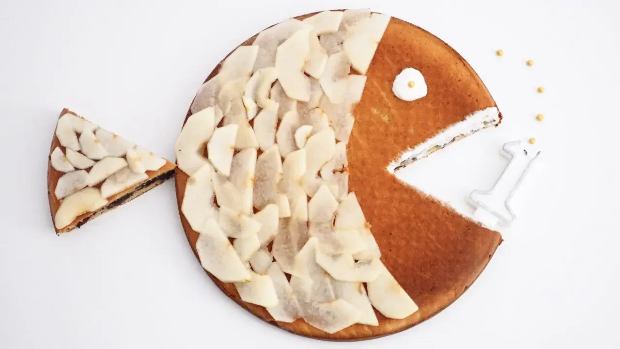 Gâteau en forme de poisson pour enfant, décoré de fines tranches de poire. Une part a été retirée, comme si le poisson mangeait.