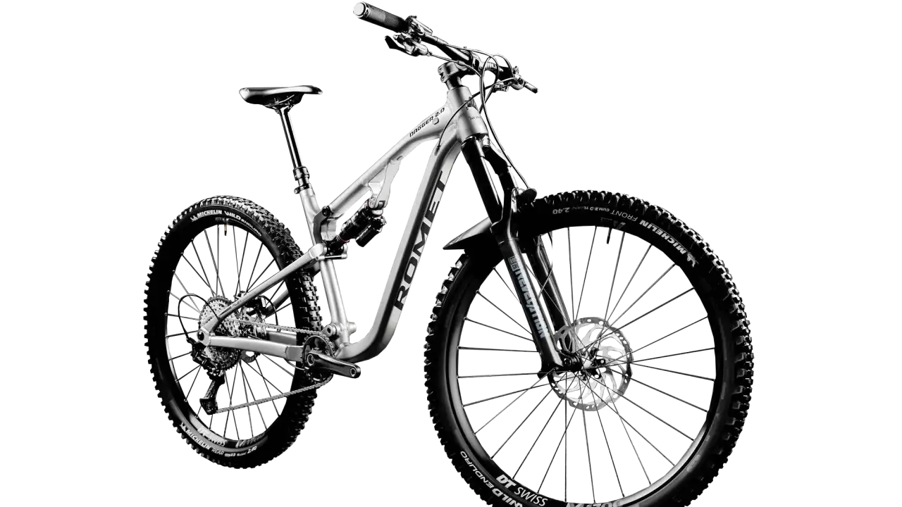 Srebrny rower górski z pełnym zawieszeniem, z oponami Michelin Wild Enduro i obręczami DT Swiss M1700. To przykład marki rowerowe premium.
