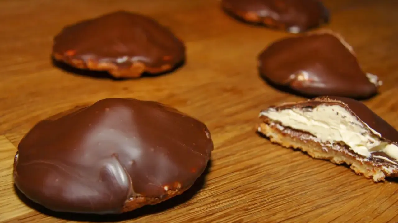 Chokladbiskvier recept: Läckra chokladöverdragna biskvier med krämig fyllning på en träyta.