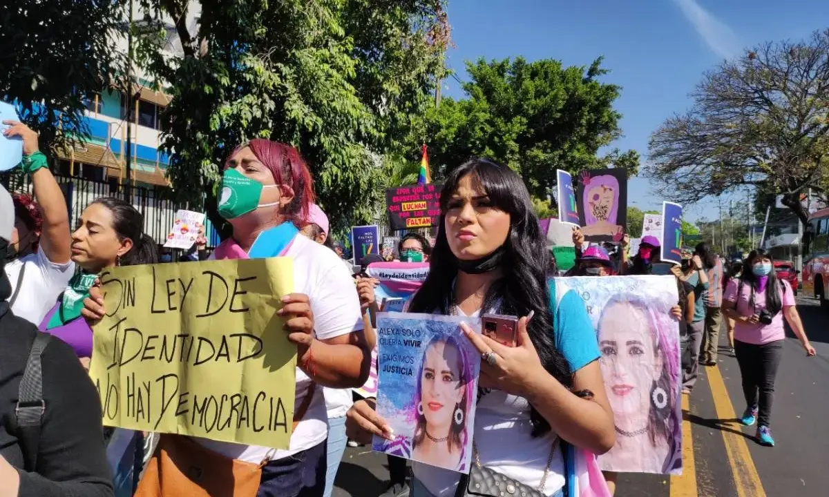 Protesters in El Salvador hold signs demanding identity rights and justice. One sign reads "Without identity law, there is no democracy.