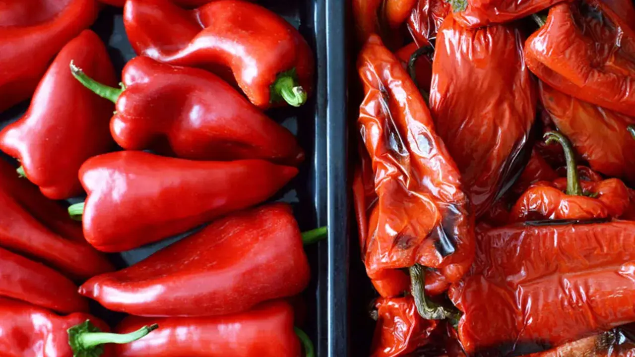 Dos recipientes llenos de pimientos rojos. A la izquierda, pimientos frescos y brillantes. A la derecha, pimientos asados, con la piel arrugada y un tono más oscuro.