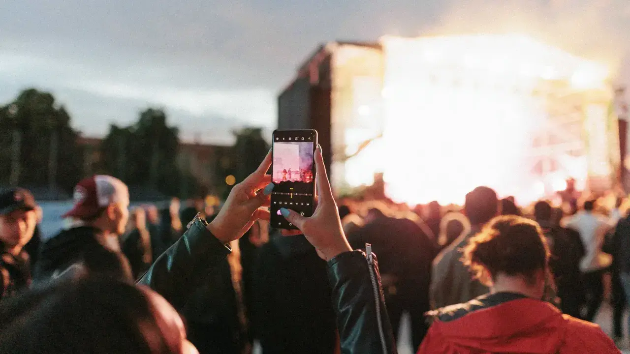 Publik njuter av en konsert i Skellefteå, Sverige. En person filmar scenen med sin mobiltelefon.