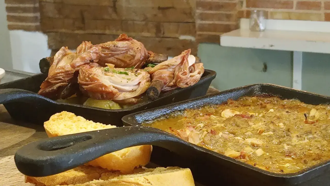 Deliciosa comida típica de Cuenca: pollo asado y un guiso con pan.