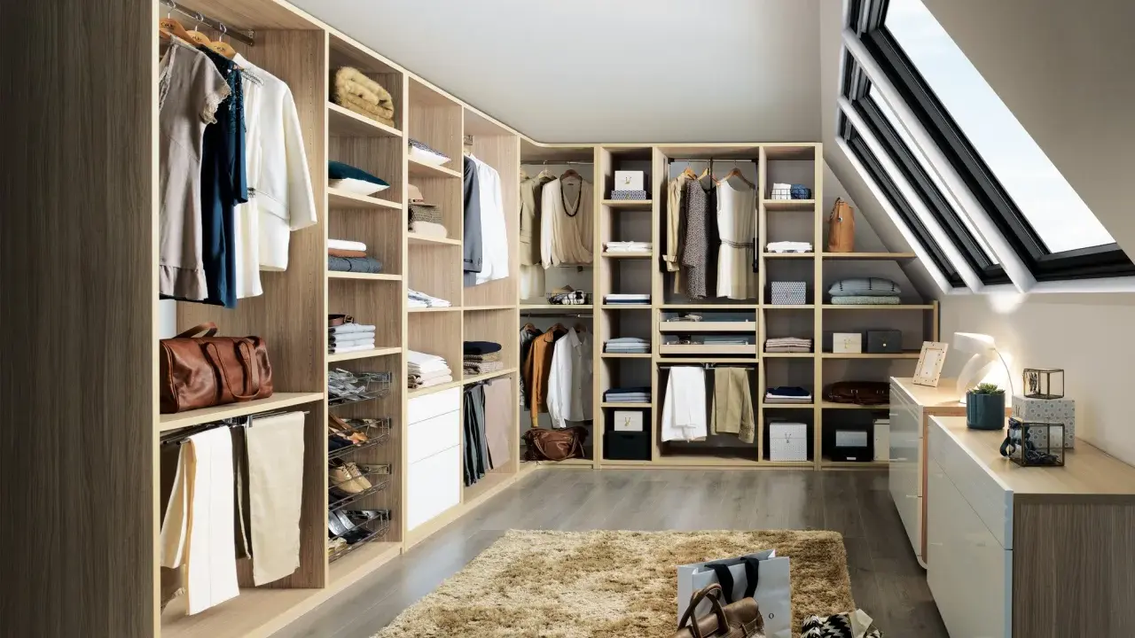 Un dressing bien organisé pour savoir comment ranger son dressing : vêtements suspendus, étagères remplies, tiroirs et accessoires à portée de main.