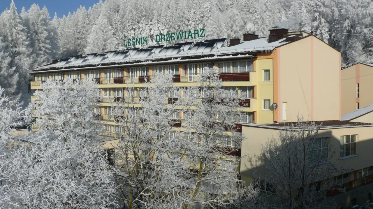Sanatorium Leśnik Drzewiarz w Krynicy-Zdroju, ul. Podgórna 1, otoczone zimowym lasem.