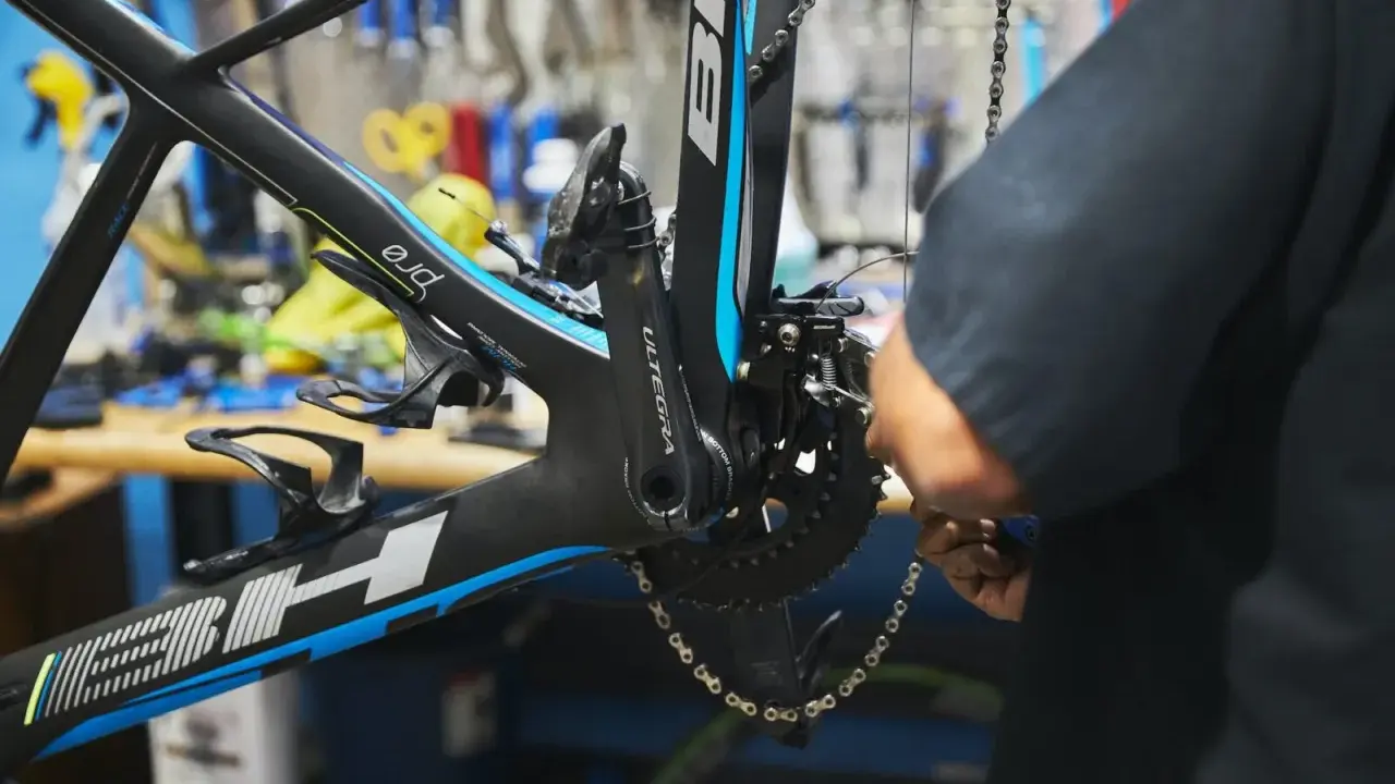 Mechanik dokonuje regulacji przedniej przerzutki w rowerze szosowym BH.