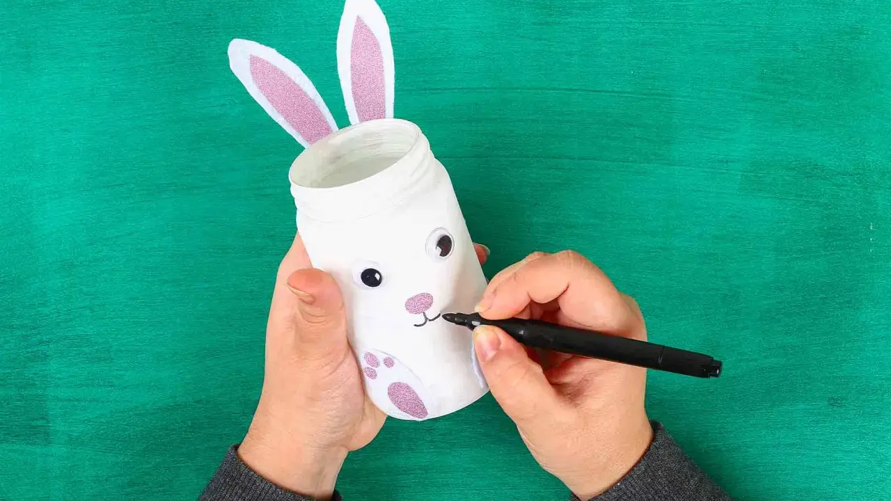 Mani che creano un coniglietto pasquale con un barattolo, un'idea per lavoretti di Pasqua facili maestra Mary.