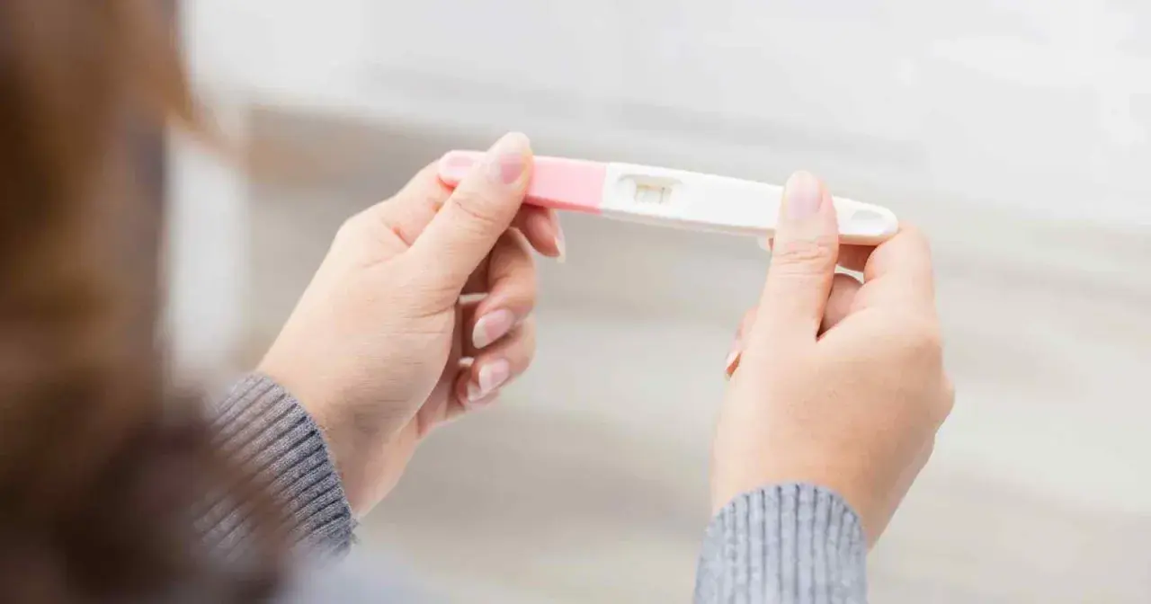 Kvinna håller graviditetstest. Ett streck syns, vilket indikerar negativt resultat, trots att hon känner sig gravid i vecka 7.