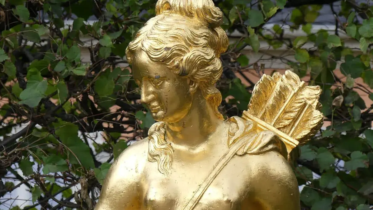 Statue dorée d'Artémis, déesse de la chasse, portant un carquois rempli de flèches sur son épaule.