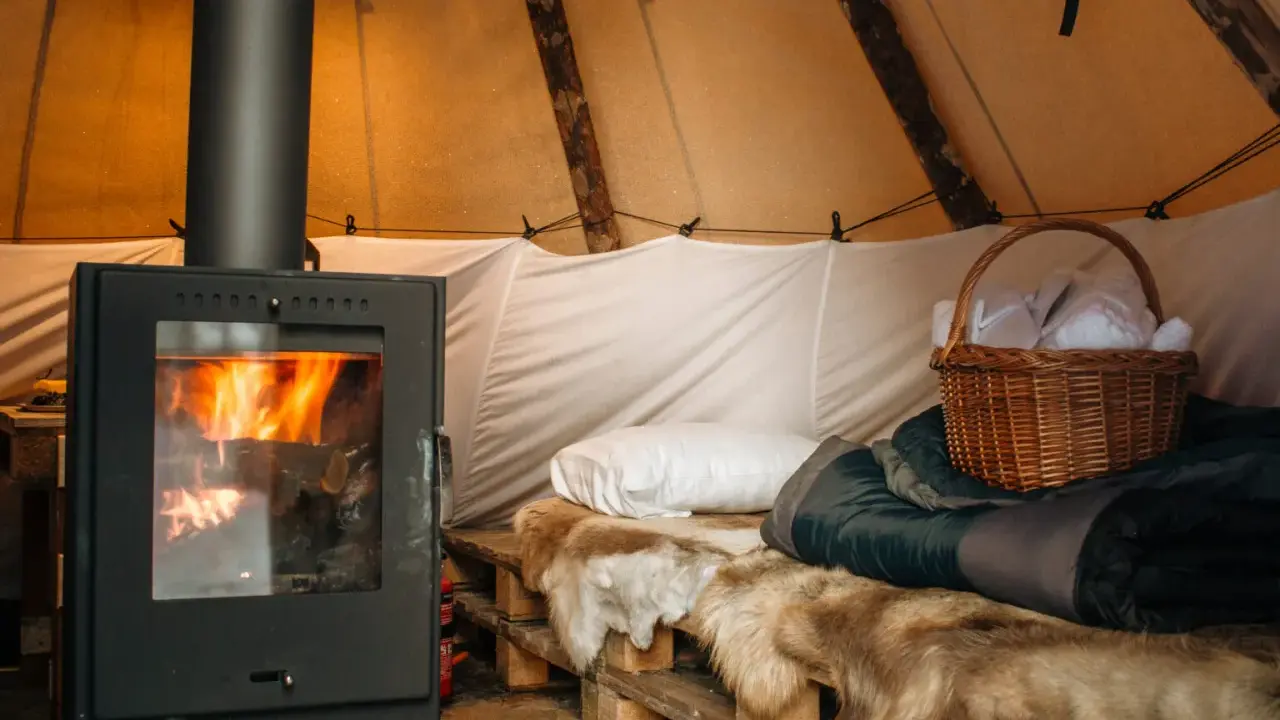 Mysig moskoselkåta med sprakande kamin, renskinn och en korg med tofflor.