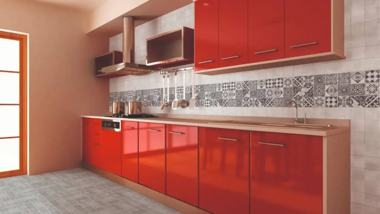 Cocina moderna con gabinetes rojos brillantes y una cenefa de azulejos con patrones geométricos en blanco y negro.