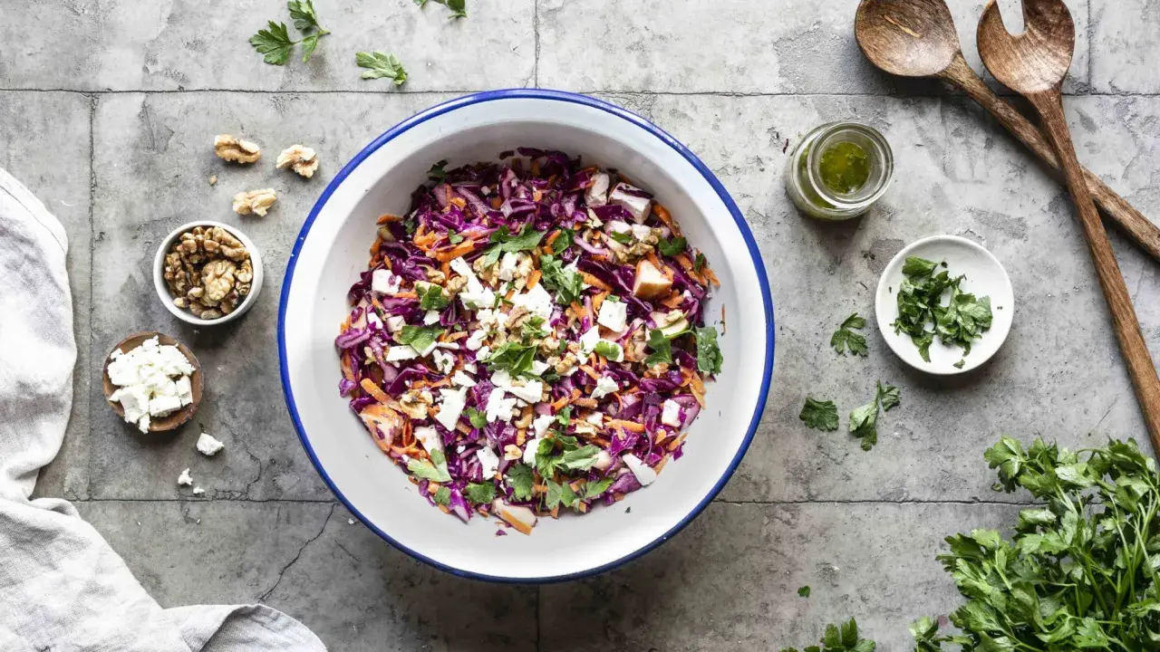 Frischer rotkohlsalat mit feta, karotten, walnüssen und Petersilie, bereit zum Servieren.
