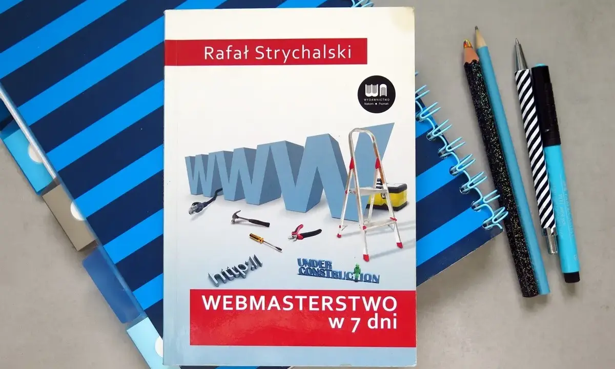 Okładka książki "Webmasterstwo w 7 dni" z grafiką WWW, narzędziami i drabiną, obok zeszytów i długopisów.