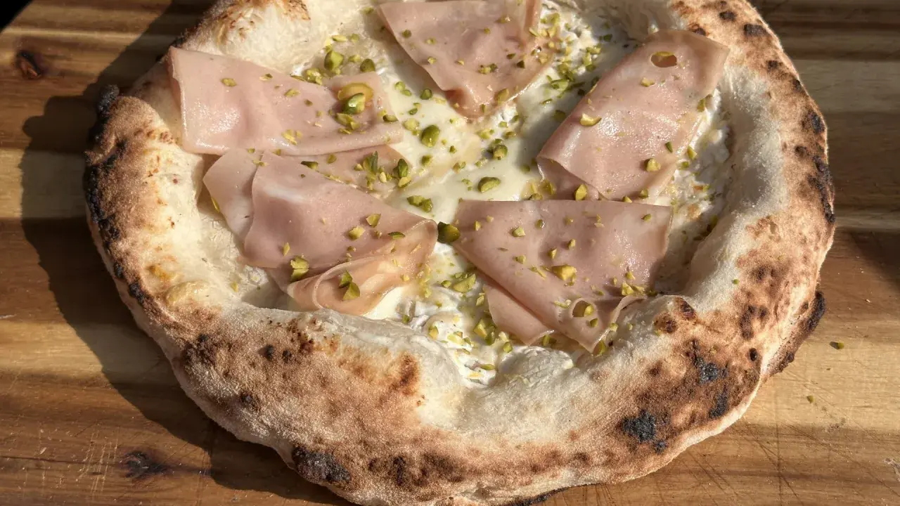 Pizza mit Mortadella und Pistazien auf luftigem pizzateig mit trockenhefe.