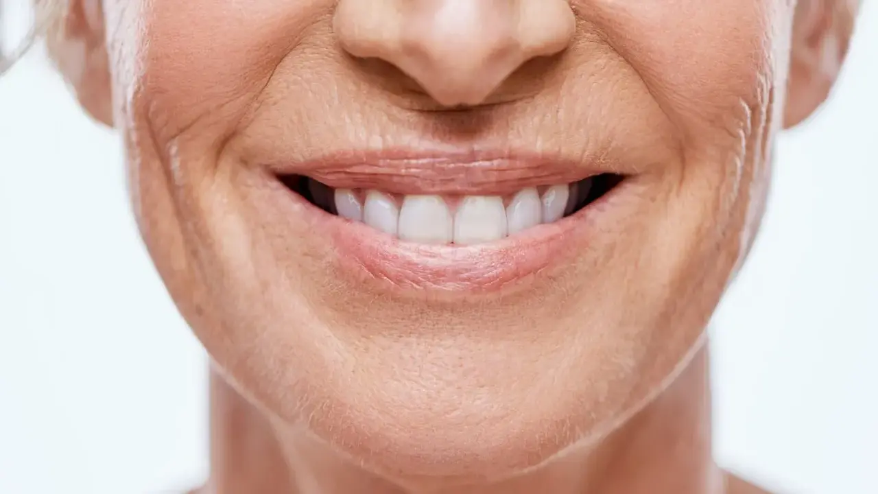 Sonrisa de mujer con piel madura, mostrando cómo disimular el surco nasogeniano con técnicas de maquillaje y cuidado facial.