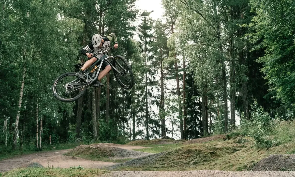 Mountainbike-åkare flyger genom luften i en skogspark nära Stockholm.