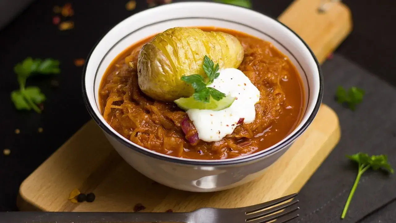 Un plat réconfortant de cuisine des terroirs aujourd'hui : choucroute garnie avec une pomme de terre Hasselback et une touche de crème.