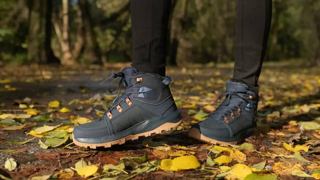 Jesienne buty trekkingowe na tle liści. Idealne, by dowiedzieć się, jak się ubrać w góry jesienią.