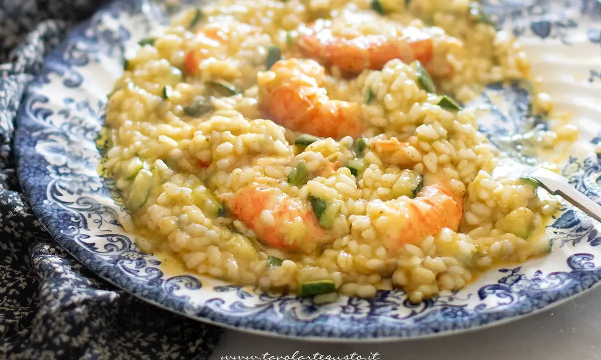 Risotto cremoso con zucchine e gamberetti, un piatto estivo da gustare.